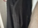 a black shirt hanging on a hanger in a closet