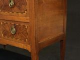 a small wooden chest of drawers with a marble top