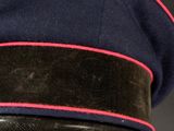 a close up of a military hat with a red stripe on it