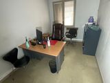 a desk with a chair and a refrigerator in a room