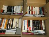de nombreux livres qui se trouvent dans une boîte posée par terre