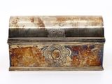 une vieille boîte en métal posée sur une surface blanche