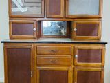 a wooden cabinet with glass doors and drawers on it