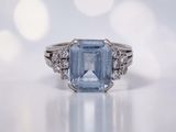 gros plan d'une bague avec une topaze bleue entourée de diamants