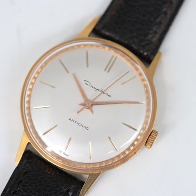une image d'un gros plan d'une montre-bracelet sur une surface blanche