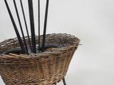 a wicker basket with a bunch of sticks in it