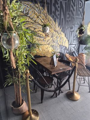 une table et des chaises devant un mur sur lequel est accrochée une peinture