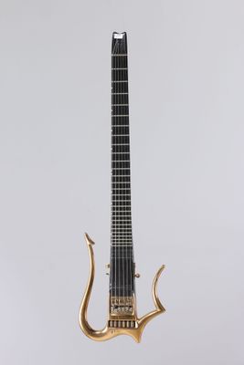 un gros plan d'une guitare posée sur un support, sur fond blanc