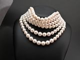 a close up of a necklace with pearls on a mannequin