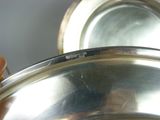 a person holding a silver plate with a handle