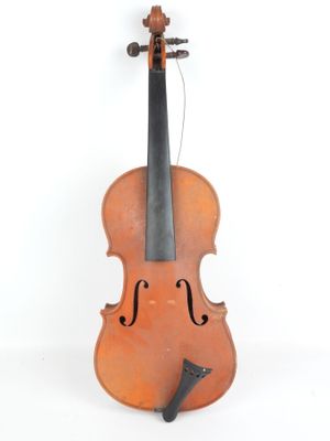 un vieux violon posé sur une surface blanche, près d'un mur blanc