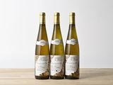 trois bouteilles de vin posées sur une table en bois