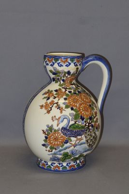 un vase blanc muni d'une anse bleue posé sur une table