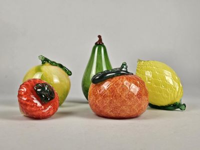 trois figurines représentant différents fruits et légumes posées sur une table