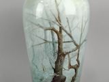un vase orné d'un arbre, posé sur une table