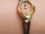 Quelqu'un porte une montre-bracelet avec un bracelet en cuir marron.