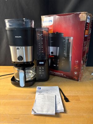 une cafetière, un mixeur et une tasse posés sur une table