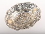 une assiette en argent finement ouvragée, ornée d'un motif décoratif