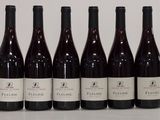 six bottles of wine are lined up in a row on a table