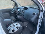 l'intérieur d'une petite voiture, avec la portière ouverte et le volant au centre de l'habitacle