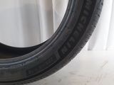 a close up of a tire on a white surface with a white curtain in the background