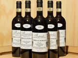 six bouteilles de vin posées sur un tonneau en bois