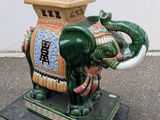 une statue d'éléphant assis sur un socle