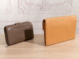 two leather wallets sitting on top of a table next to each other