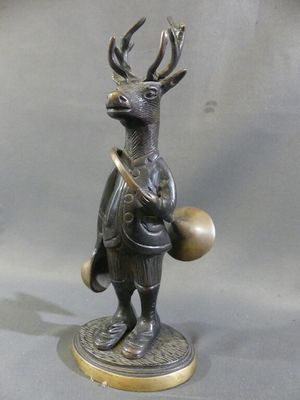 a bronze statue of a deer with a drum and a bell