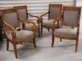 three wooden chairs in a room with a piano in the background