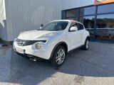 La Nissan Juke blanche est garée devant un immeuble.