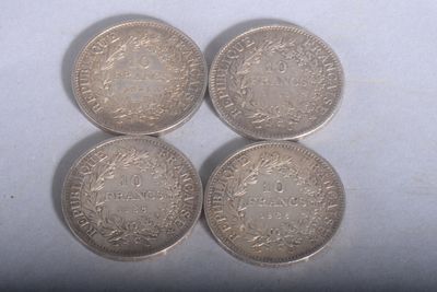 four silver coins sitting on top of each other on a white surface