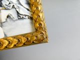 a gold frame with a picture of a man and a woman on it