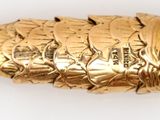 a close up of a gold pen on a white surface