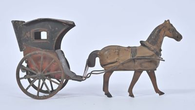 un cheval en jouet tirant une calèche dans laquelle se trouve un homme