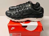 une chaussure de course Nike noire et blanche posée sur une boîte rouge
