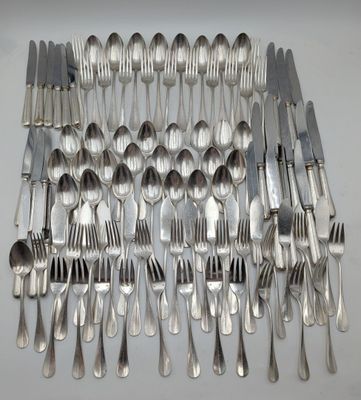 many forks and spoons laid out on the table