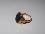 a gold ring with a black stone on it