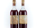 deux bouteilles de vin posées l'une à côté de l'autre sur une surface blanche
