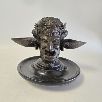 une statue représentant un homme tenant un couteau sur une assiette