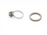 two silver rings and a silver ring on a white surface