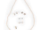 a close up of a necklace and earring set on a white background