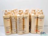 six flacons de lait solaire Nuxe posés sur une surface blanche