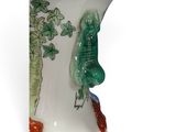 a white vase with a green bird and carrots on it