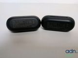 an image of a pair of black ear buds sitting on top of a table