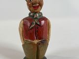 a figurine of a man wearing a hat and vest