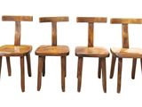 three wooden chairs sitting next to each other on a white surface