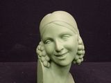 a green statue of a woman with a smile on her face