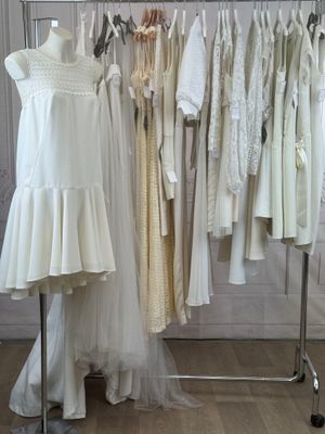 a lot of dresses hanging on a rack in a room