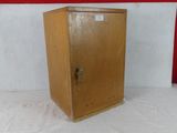 a small wooden cabinet with a door on it